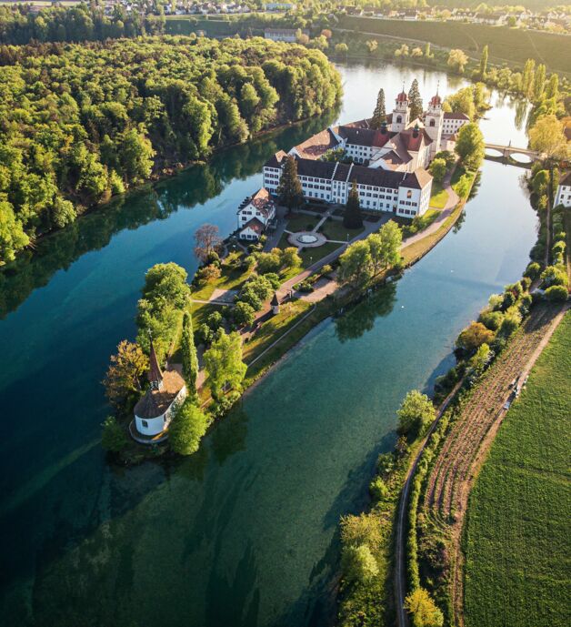 Fotografie von Pascal Debrunner - Ein Schloss umgeben von einem kleinen See