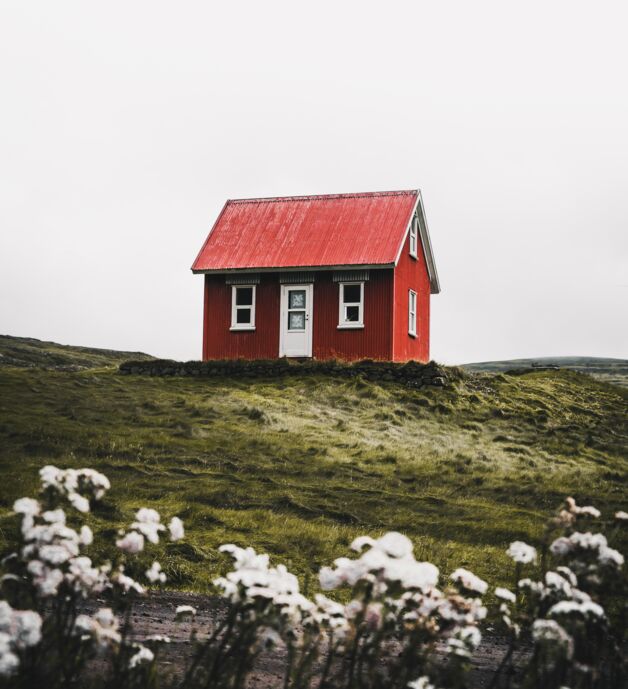 Fotografie von Luke Stackpoole - ein rotes Haus auf einer grünen Wiese